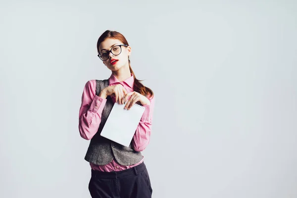 Atractiva chica con estilo en gafas, camisa rosa posando, sosteniendo un cuaderno en la mano — Foto de Stock