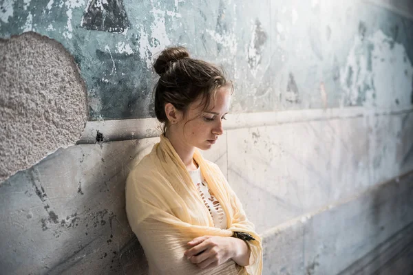 Menina triste reza no templo, em ombros de lenço amarelo — Fotografia de Stock