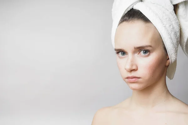Красивая женщина с полотенцем на голове смотрит в камеру , — стоковое фото