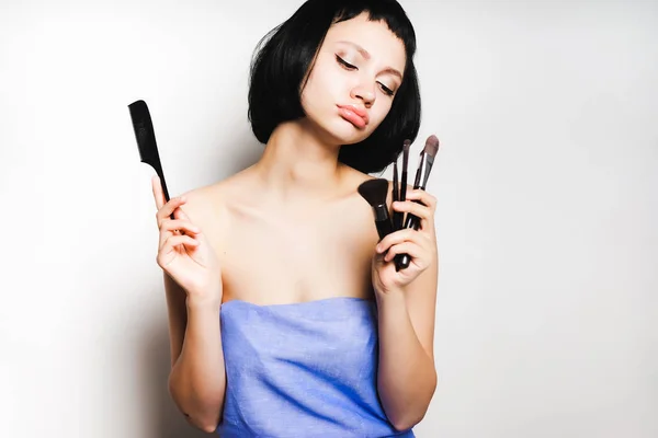 Θλιβερή νεαρή κοπέλα με τα μαύρα μαλλιά κατέχει ένα πινέλο για το make up — Φωτογραφία Αρχείου