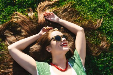 Mutlu yaz gülümseyen kadın rahatlatıcı park, güneş gözlüğü, sağlıklı dişler