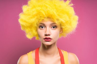 Kameraya bir pembe genç kız güzel bir sarı palyaço peruk bakar