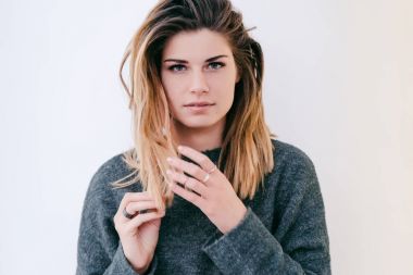 Beyaz bir arka plan üzerinde ciddi kız saçları ile oynanır