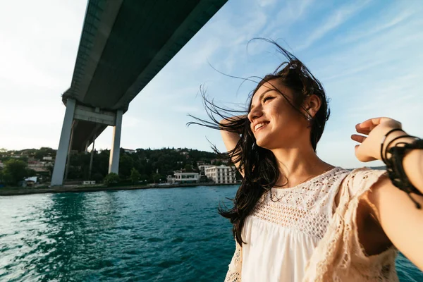 Giovane libertà ragazza felice sta viaggiando in barca sotto un ponte moderno — Foto Stock