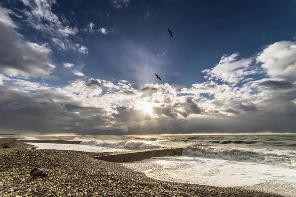 Playa de piedra abandonada al atardecer en un clima turbulento —  Fotos de Stock