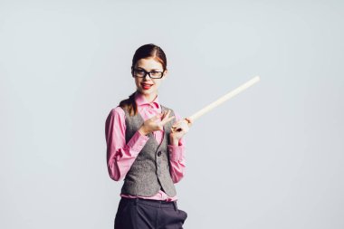 Gözlüklü kız öğrenci bir cetvel elinde tutar.