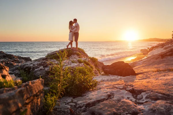 Молодая пара целуется на фоне заката моря — стоковое фото