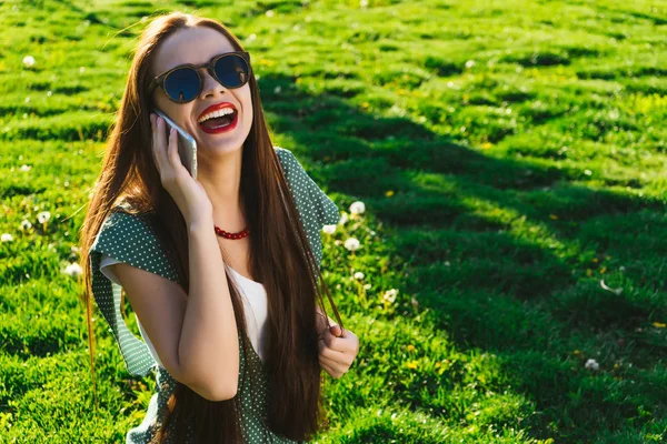 Donna di faccia sorpresa che parla con mobile su un'erba — Foto Stock