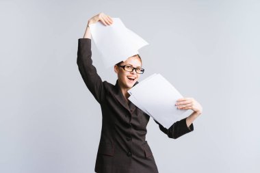 belgeleri sallayarak mutlu gülen genç kız ofis çalışanı gözlük ve sıkı siyah takım elbise,