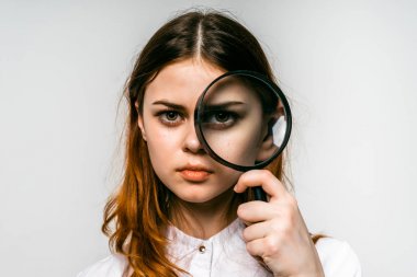 Kızıl saçlı kız Beyaz gömlekli Büyüteç camı, beyaz arka plan üzerinde görünüyor.