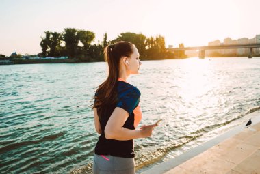 Spor giysileri genç fitness kızı Irmak, kulaklıklar müzik dinler çalışır