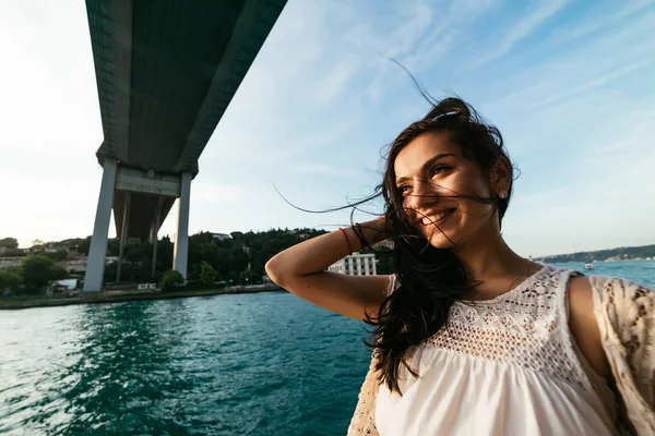 Genç özgürlük mutlu kız tekneyle modern köprü altında seyahat