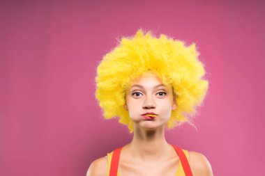 Bir kız bir palyaço kostüm ağzı tam pembe bir arka plan üzerinde duruyor