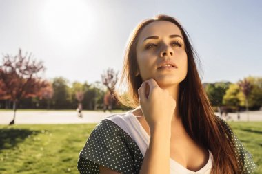 Park, yeşil çim çevresinde gülümseyen mutlu kadın portresi kapatın