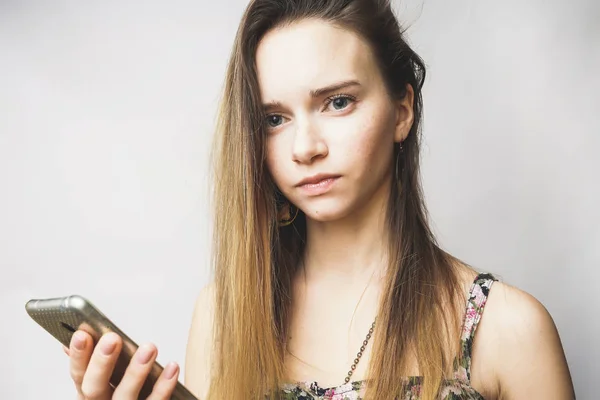 Jonge vrouw met telefoon op een witte achtergrond — Stockfoto