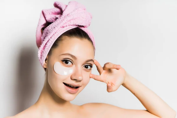 Ragazza felice con un asciugamano sulla testa applicare la crema sul viso — Foto Stock