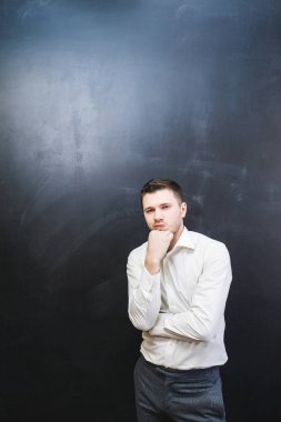 başarılı genç adam bir siyah arka plan üzerine bir şey hakkında düşünüyor