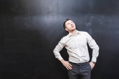 düşünceli, üzerinde siyah bir arka plan bakmak beyaz bir gömlek başarılı genç adam
