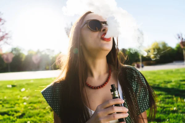 Felice moda sorridente Donna in occhiali da sole fumo vaporizzatore sulla strada, fumo — Foto Stock