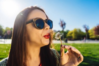 Mutlu gülümseyen komik surat kız darbe karahindiba, yaz güneş gözlüğü, günbatımı