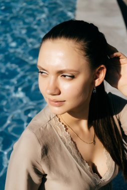 Bir yaz elbiseli bir genç kız büyük bir çeşme dinleniyor