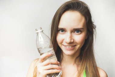 Şişe su üzerinde beyaz bir arka plan ile oldukça parlayan kız 