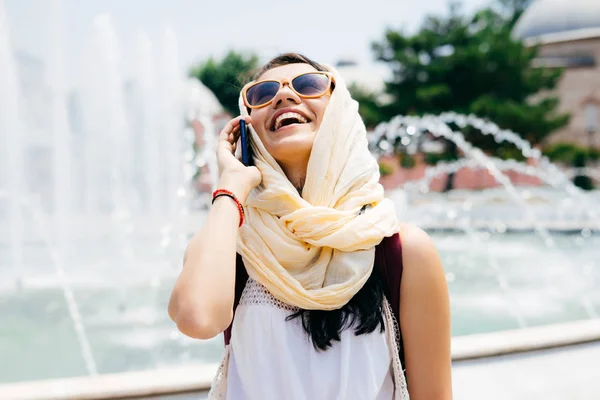 Una chica en vacaciones de verano en un país musulmán viaja y habla por teléfono, se ríe — Foto de Stock