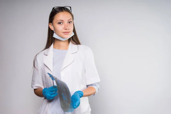 Ung sjuksköterska flicka med glasögon på en vit bakgrund — Stockfoto