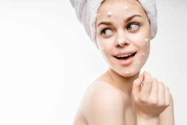 Kız beyaz bir arka plan üzerinde gülümseyen başında bir havlu ile