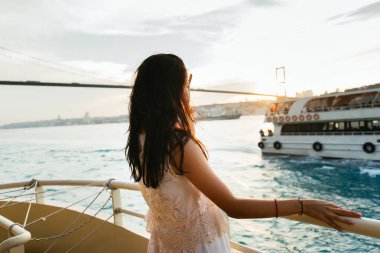Genç kız seyahat sırasında bir yat gezisi, sunset ve yelken feribot ile bakar rahatlatır
