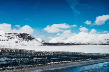 Kuzeyde, mavi soğuk gök, yüksek karla kaplı dağlar, her yerde kar beyaz