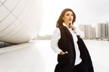 siyah bir takım elbise şık iş kız Bakü yürür, güzel mimari sahiptir