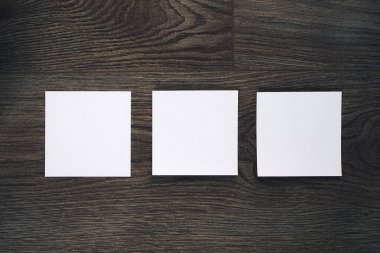 bir koyu ahşap yüzeye üç beyaz küpleri vardır