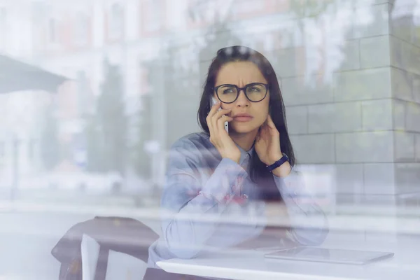 Mulher de negócios triste usando óculos falando ao telefone sobre o trabalho — Fotografia de Stock