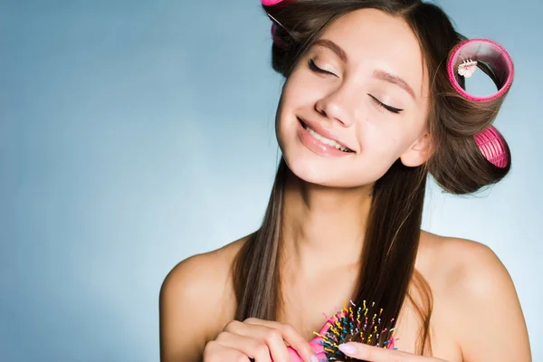 Szczęśliwa dziewczyna wygląda po jej włosy, sprawia, że loki za pomocą lokówki — Zdjęcie stockowe