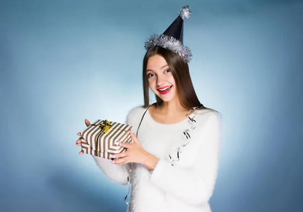 Heureuse jeune fille en prévision du nouvel an et de Noël, tenant un cadeau dans les mains, souriant, attendant le Père Noël — Photo