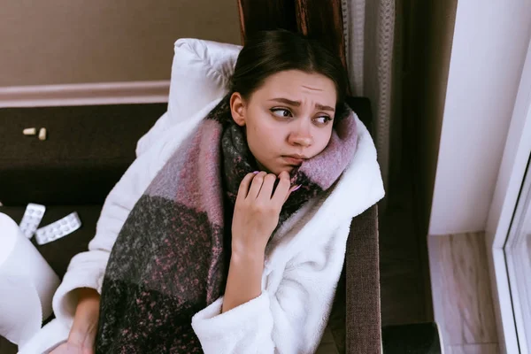 Грустная девушка заболела больным горлом, на горле шарф, из-за холодной зимней погоды — стоковое фото