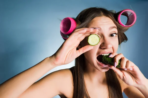 Bir genç kız yüzünü bir salatalık ile nemlendirici bir kıvırıcı saçını yapıyor bir partiye, gidiyor — Stok fotoğraf