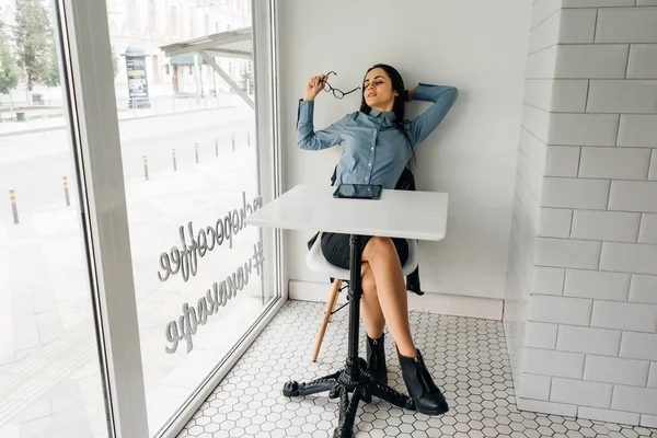 Affari ragazza freelance stanco di lavorare, si sente stressato, si siede a un tavolo in un caffè — Foto Stock