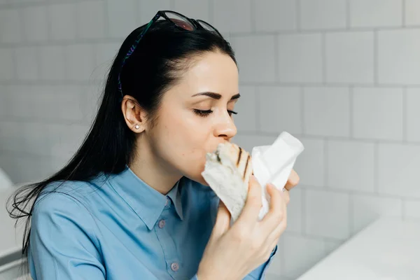 Junge geschäftige Geschäftsfrau mit Brille frühstückt in einem Café und arbeitet — Stockfoto