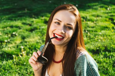 Gülümseyen kadın güneş gözlüğü, boşaltmak tutar. Gözlük ile