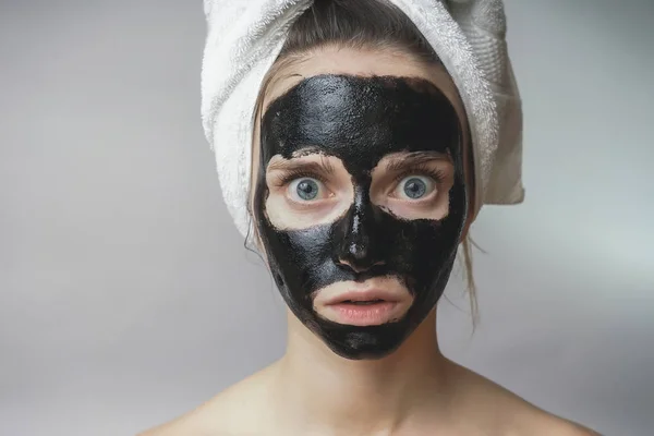 Máscara preta no rosto da mulher, sorrindo, cuidados com a pele, poro de limpeza, contra a acne — Fotografia de Stock