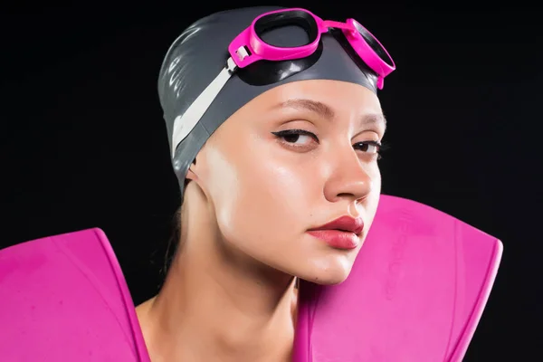 Una ragazza in cuffia e occhiali da bagno si prepara per una nuotata — Foto Stock