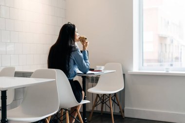 rahat bir kafede çalışıyor, Kahvaltı ve iş düşünüyorsun uzun saçlı meşgul kız serbest meslek