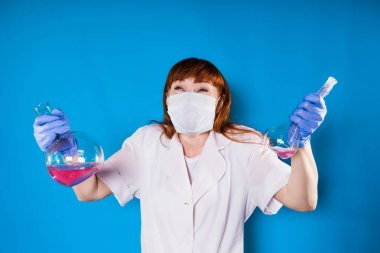 kadın bir hemşire maskeli iki şişe reaktifleri ile onun elinde tutan ve onları, izole kaldırdı