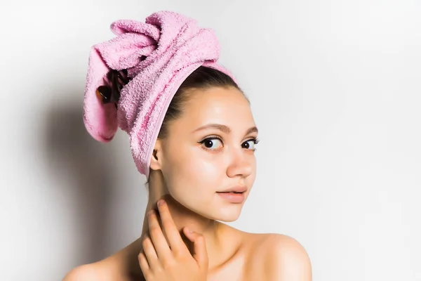 Menina bonita saiu depois de tomar banho com uma toalha rosa na cabeça e bonito olha para a câmera, isolado no fundo branco — Fotografia de Stock