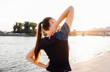 Kız nehir kıyısında koşu önce egzersizleri yapıyor