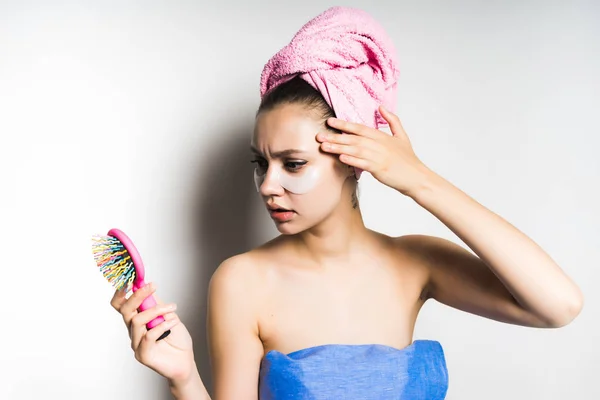 Μια κοπέλα μετά από ένα ντους με μπαλώματα στο πρόσωπό της και ψάχνουν ασαφή στον καθρέφτη από τη χτένα — Φωτογραφία Αρχείου