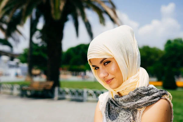 Flirtende Muslimin mit Schal sitzt im Park — Stockfoto