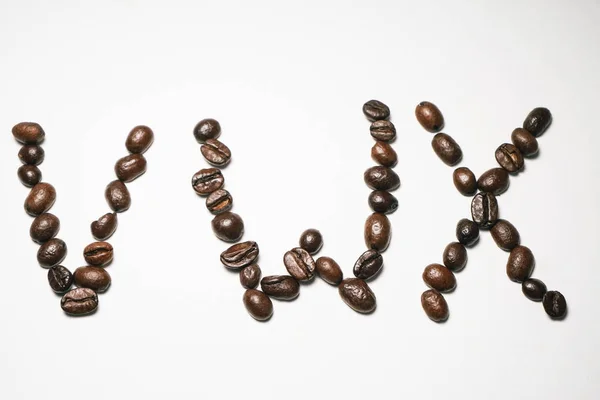 Αγγλικά γράμματα που ορίζονται από τους κόκκους του καφέ σε λευκό φόντο — Φωτογραφία Αρχείου